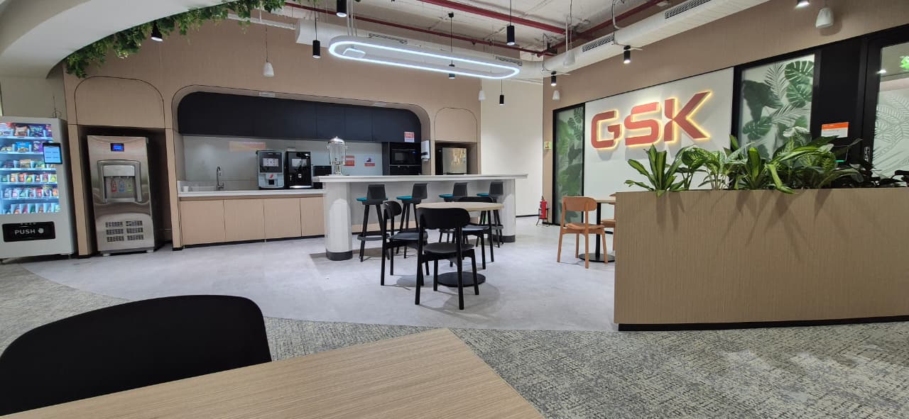 GSK office lounge seating and workstation areas with oak tables, Bengaluru