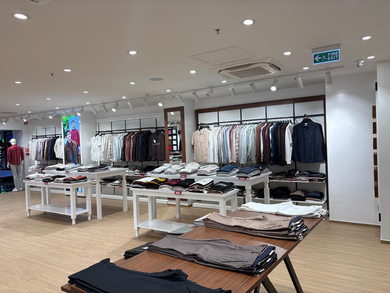 U.S. Polo Assn. shop floor with white display tables, apparel walls and track lighting in Bengaluru